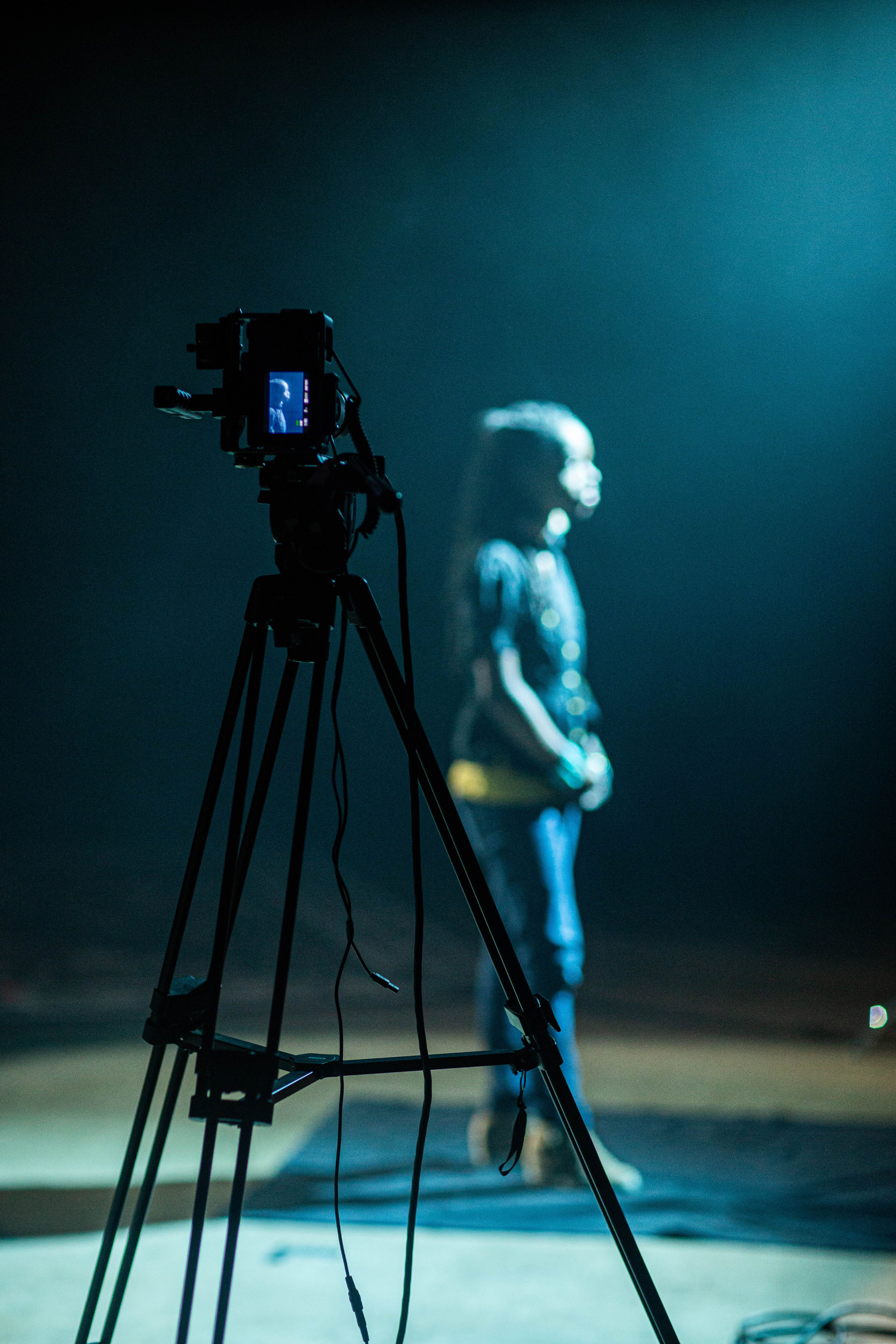 Camera on a tripod filming a performer